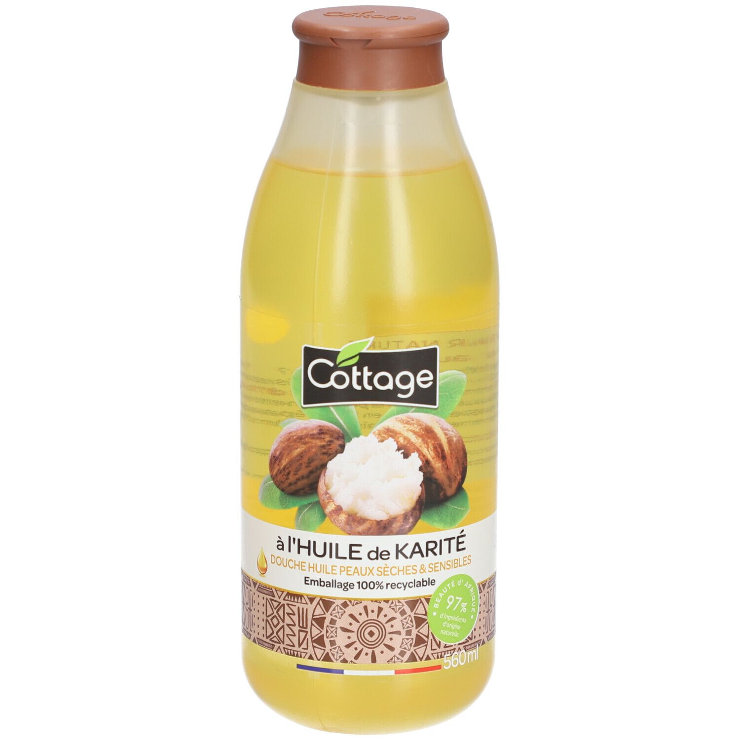 Huile de douche Cottage au karité en flacon transparent. Liquide jaune, bouchon marron.