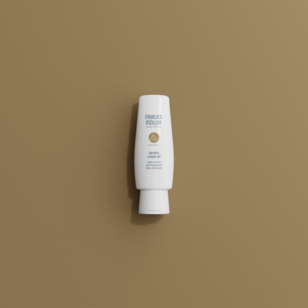 Bouteille Marlies Möller Keratin Cream Oil sur fond brun.