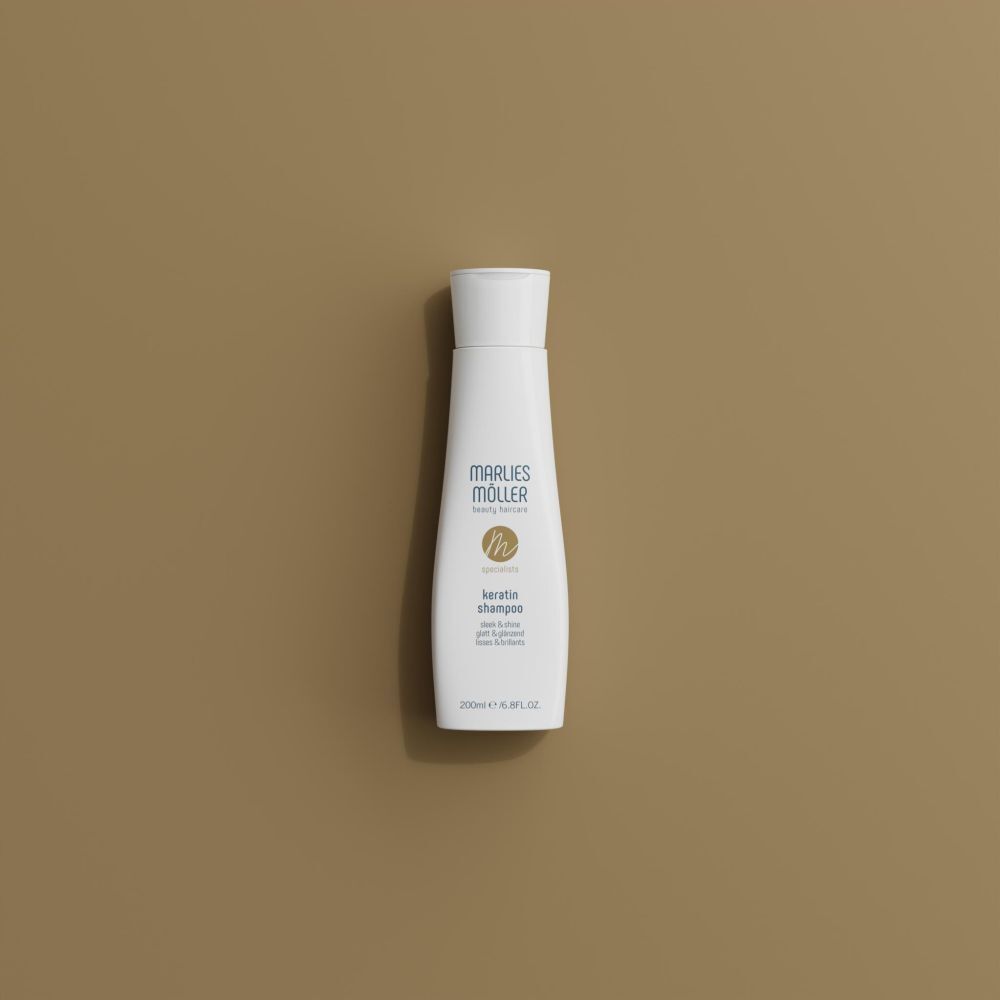 Bouteille de shampooing Marlies Möller Kératine sur fond brun.