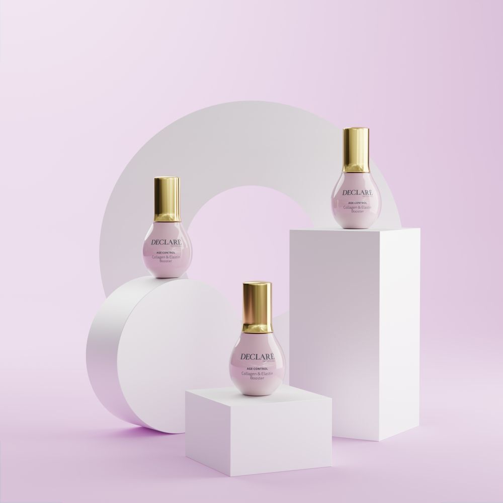 Trois flacons roses sur socles. DECLARÉ, AGE CONTROL Collagen & Elastin Booster. Arrière-plan.