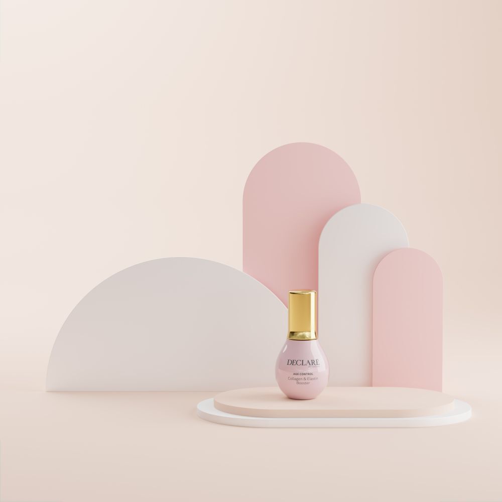 Flacon rose sur socle. DECLARÉ, AGE CONTROL Collagen & Elastin Booster. Fond avec formes.
