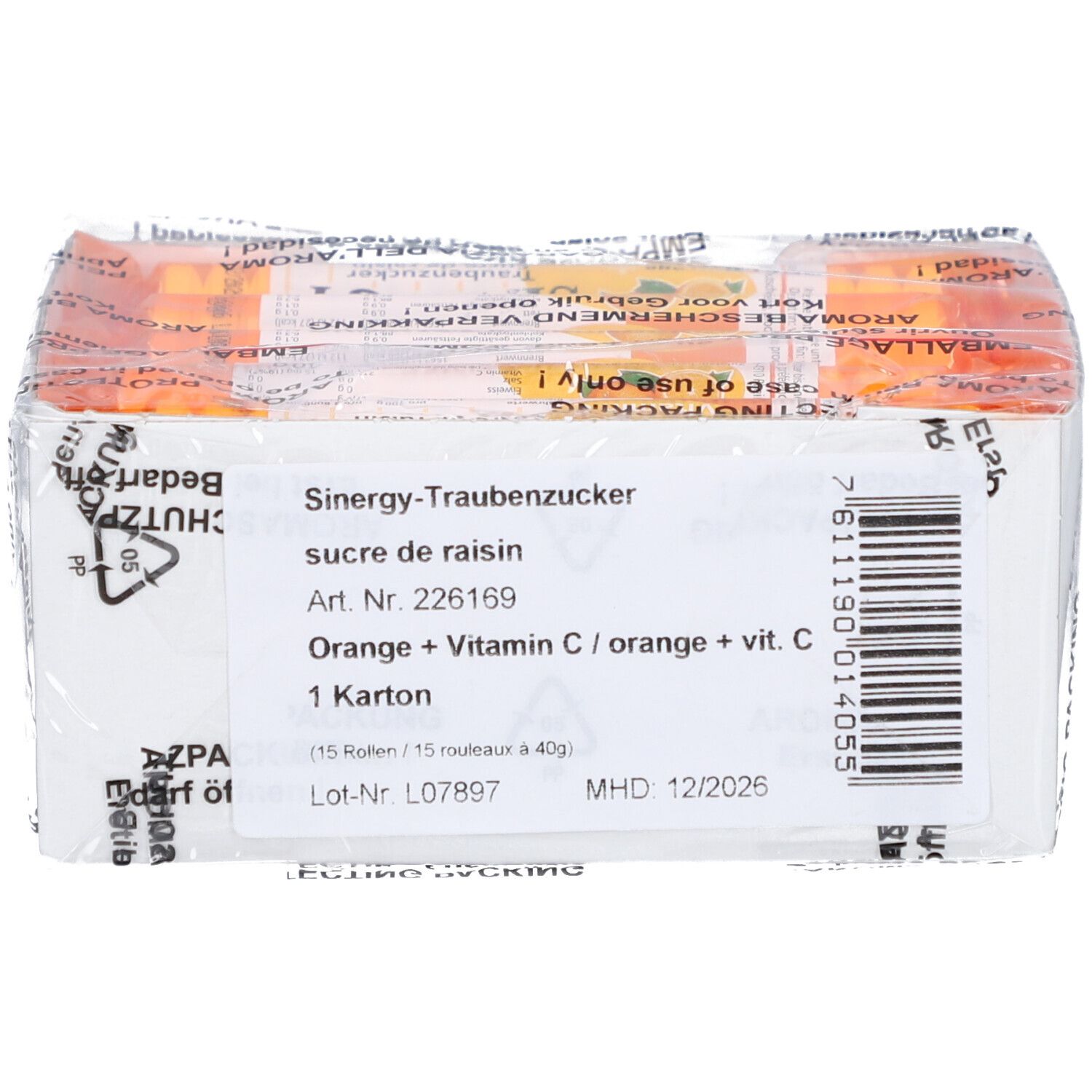 Boîte blanche avec informations produit. Texte: "SINERGY Traubenzucker", "Orange + Vitamine C". Code-barres et date de péremption.