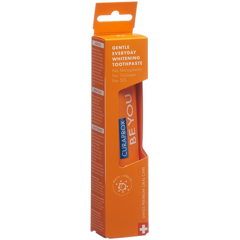Tube de dentifrice dans un emballage orange. Inscription : BE YOU, CURAPROX. 'Gentle Everyday Whitening Toothpaste'.