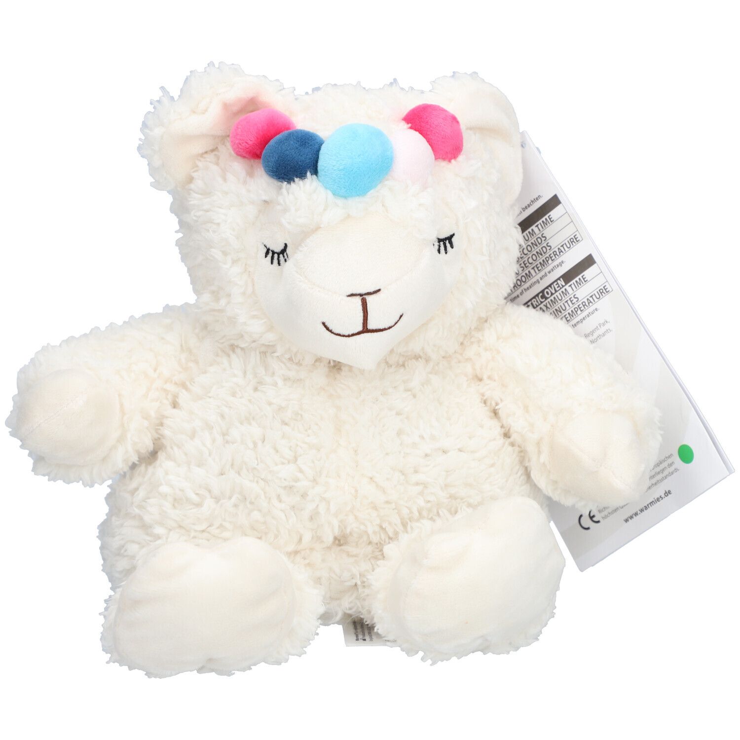 Peluche alpaga blanche avec pompons colorés sur la tête. Étiquette avec informations produit.