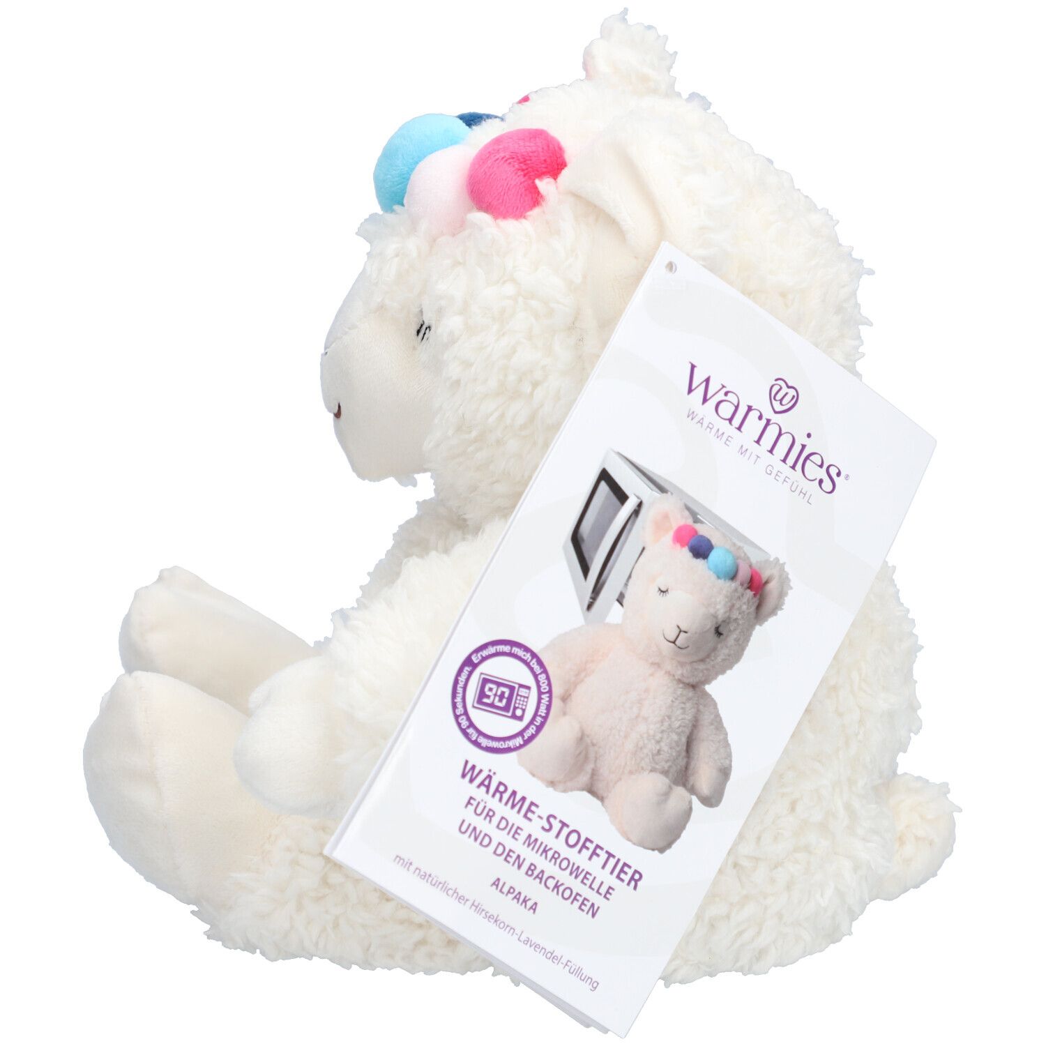 Peluche alpaga blanche avec pompons colorés. Étiquette avec informations produit et le nom de la marque Warmies.