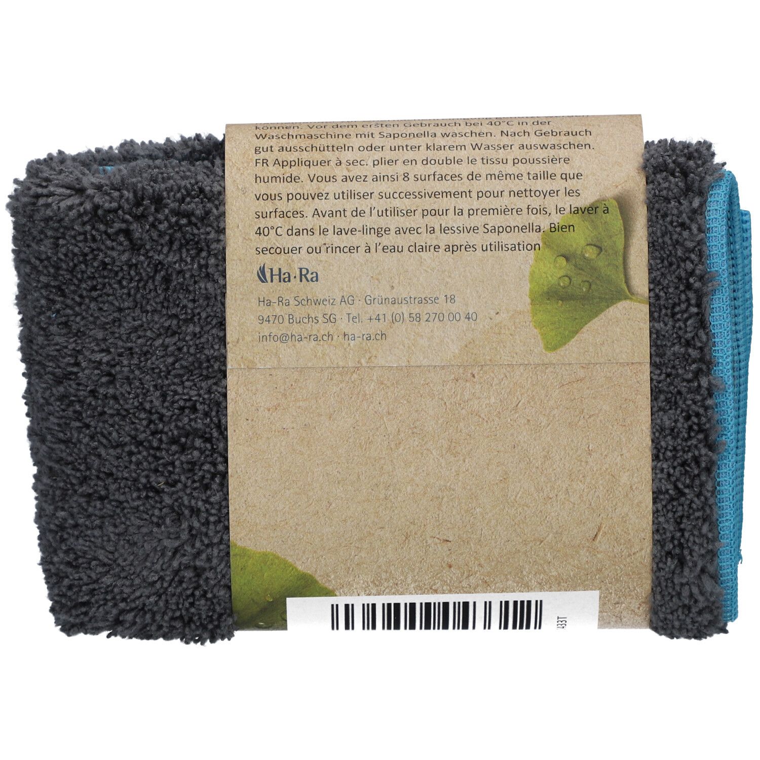 Dos du tissu HA-RA plié. Bande de carton marron avec texte et logo. Tissus bleus et gris visibles.