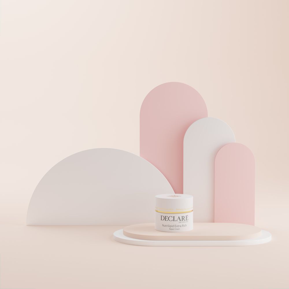 Pot blanc sur plateforme ovale. DECLARÉ Nutrilipid Extra Rich Repair Cream. Fond avec formes.