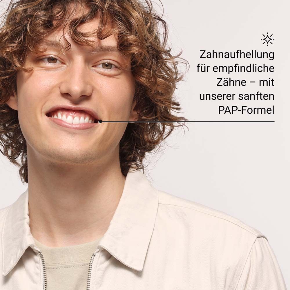 Un homme sourit. Blanchiment des dents sensibles avec la formule PAP.