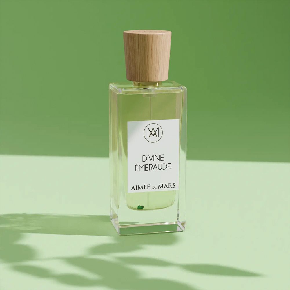 Flacon avec bouchon en bois. Inscription: Divine Émeraude, Aimée de Mars. Fond vert.