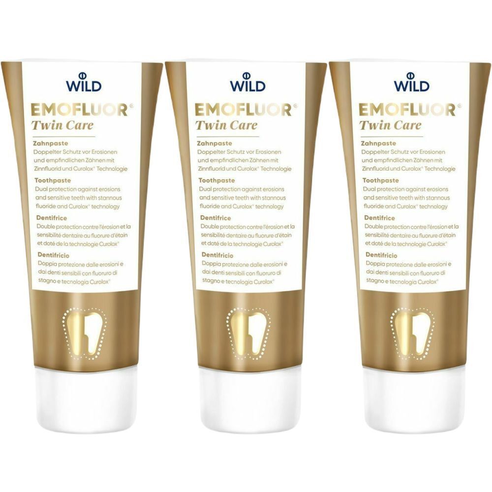 Trois tubes de dentifrice EMOFLUOR Twin Care. Tubes dorés avec bouchons blancs. Texte en allemand, anglais, français et italien.