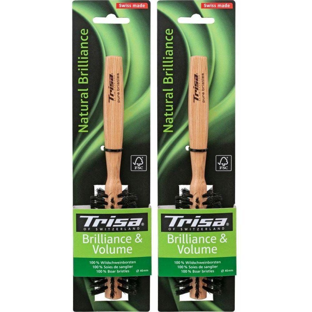 Deux brosses à cheveux emballées. Manche en bois, soies noires. Inscription : Trisa, Natural Brilliance, Swiss made. Certification FSC.