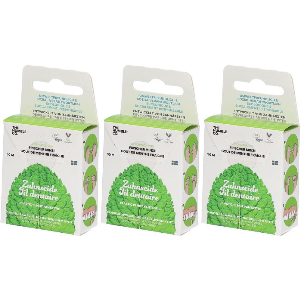 Trois boîtes de fil dentaire. Inscription : THE HUMBLE CO., Fresh Mint, 50 m. Emballage vert et blanc avec motif de feuille.