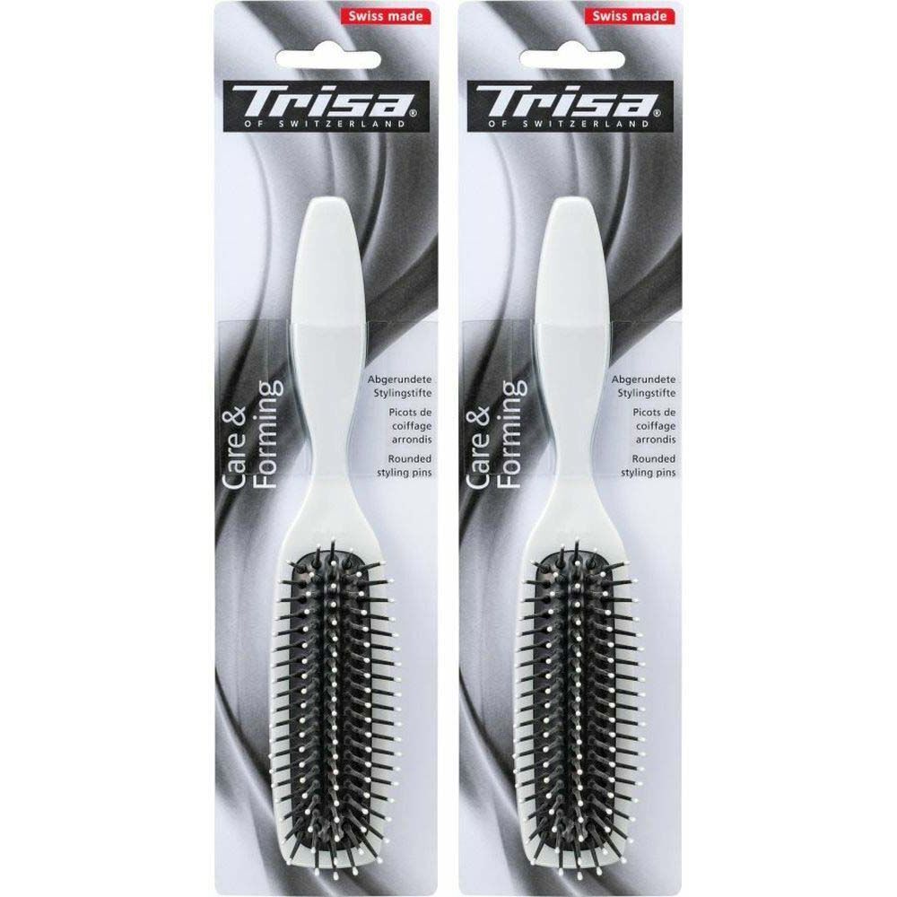 Deux brosses à cheveux blanches avec des poils noirs. L'emballage porte les mentions "Trisa" et "Swiss made".