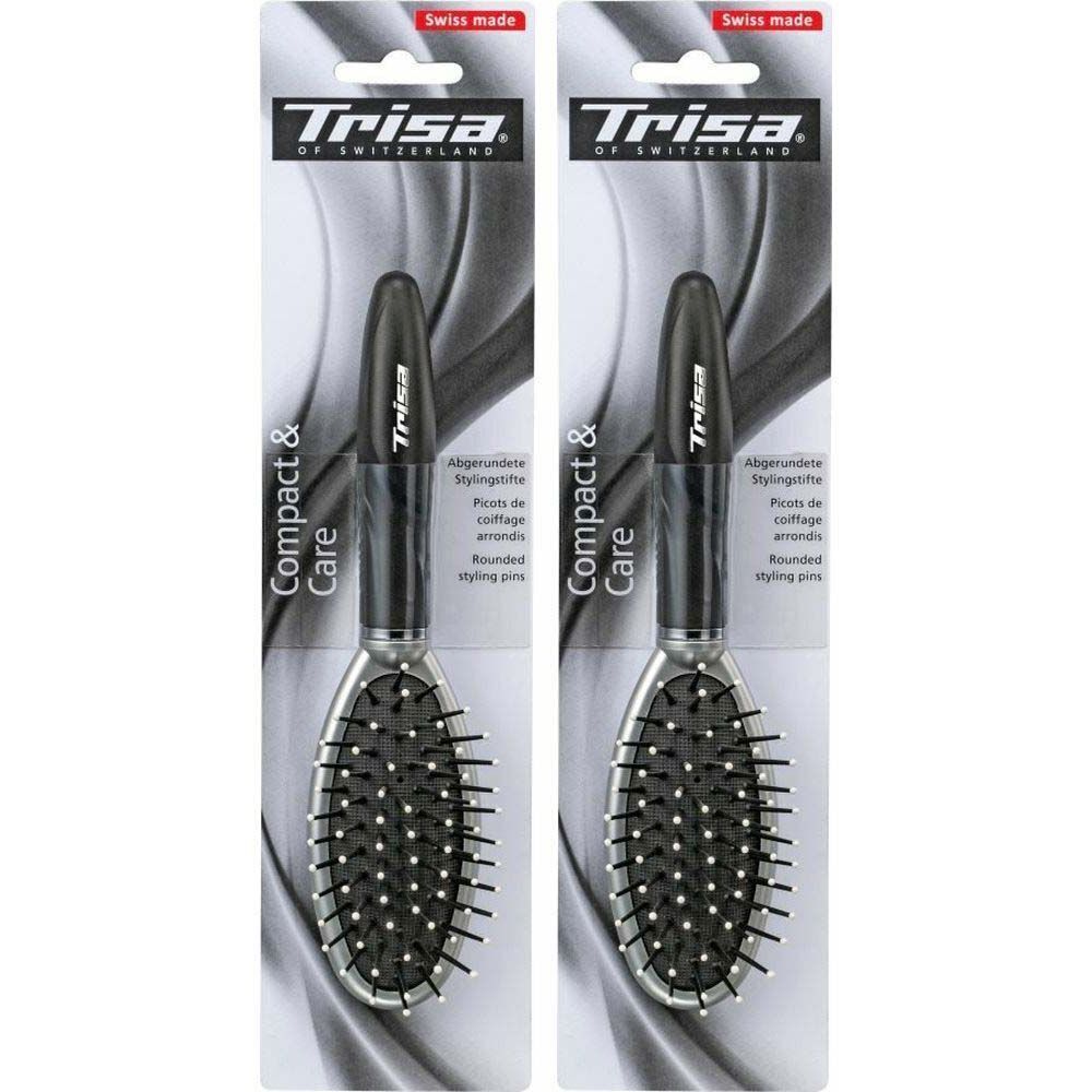 Deux brosses à cheveux ovales dans leur emballage. Soies noires, cadre argenté, manche noir. Marque : Trisa.