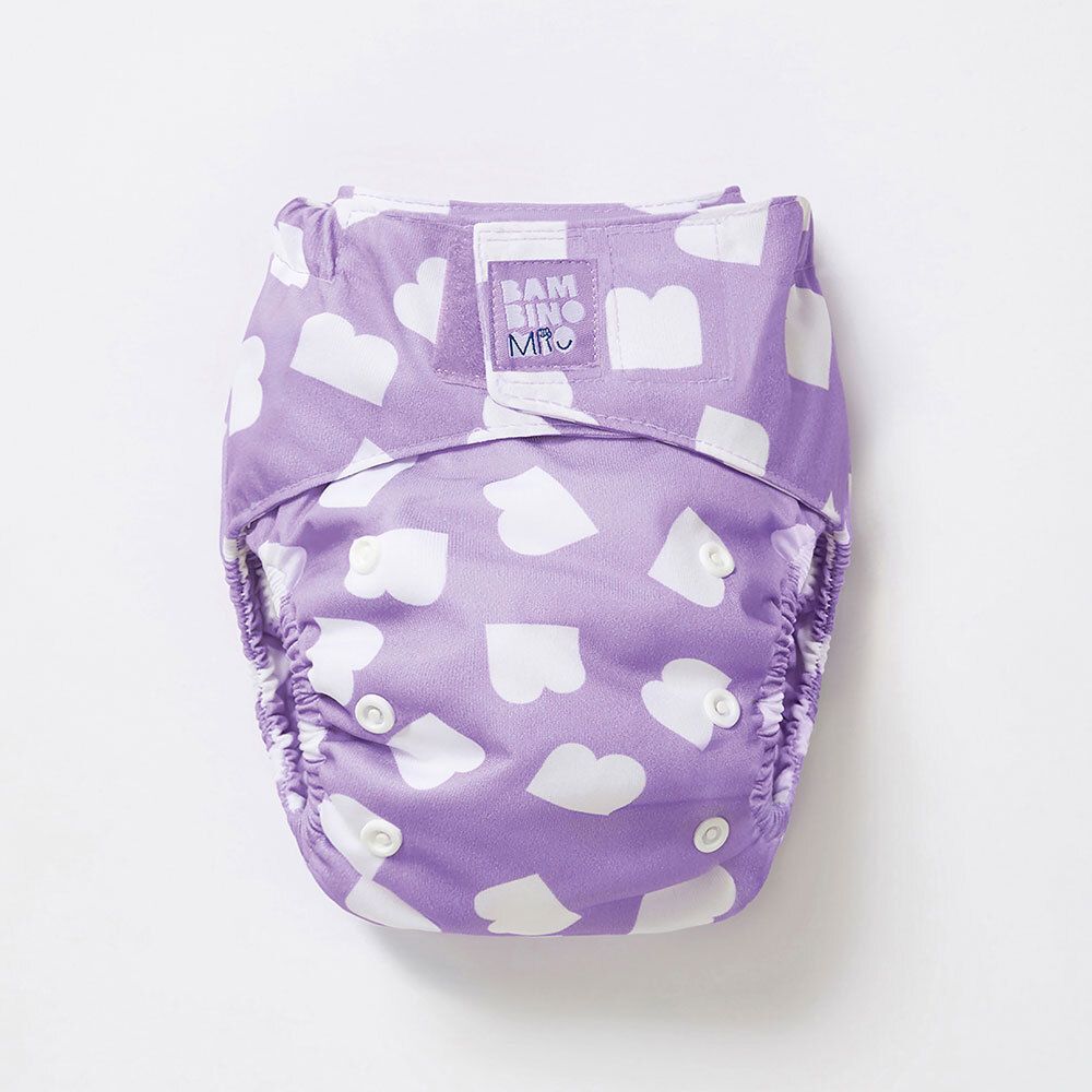 Couche lavable violette à cœurs blancs. Marque : Bambino Mio. Boutons-pression et étiquette visibles.