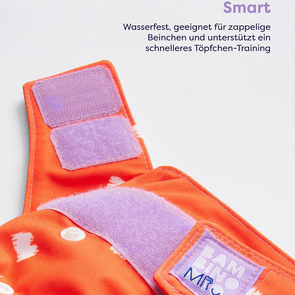 Gros plan des fermetures velcro d'une couche orange. Logo Bambino Mio.