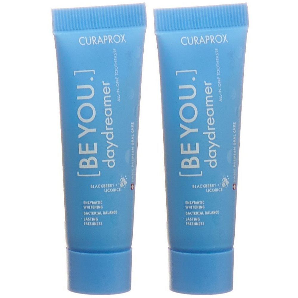 Deux tubes de dentifrice bleus. Inscription: CURAPROX, [BE YOU.] daydreamer, mûre et réglisse. Contient blanchiment enzymatique.