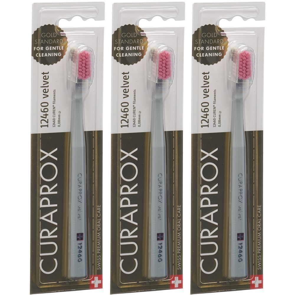 Trois brosses à dents emballées. Manches gris, poils rouges. Inscriptions: CURAPROX, 12460 velvet, Gold Standard pour un nettoyage doux.
