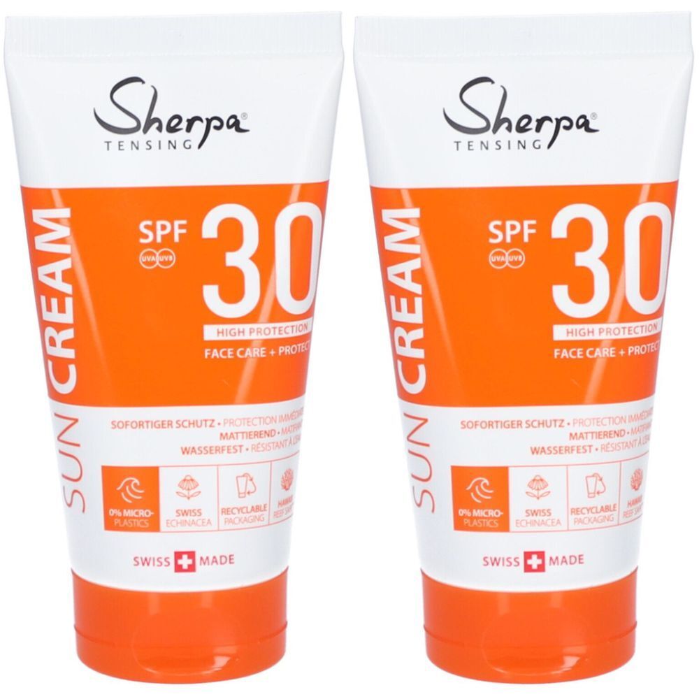 Deux tubes de crème solaire. Emballage blanc et orange avec texte et SPF 30. Produit suisse.