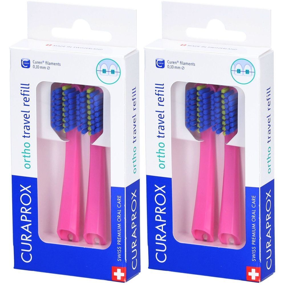 Deux recharges de brosse à dents roses dans un emballage. Soies bleues, accents jaunes. Marque CURAPROX, ortho travel refill.