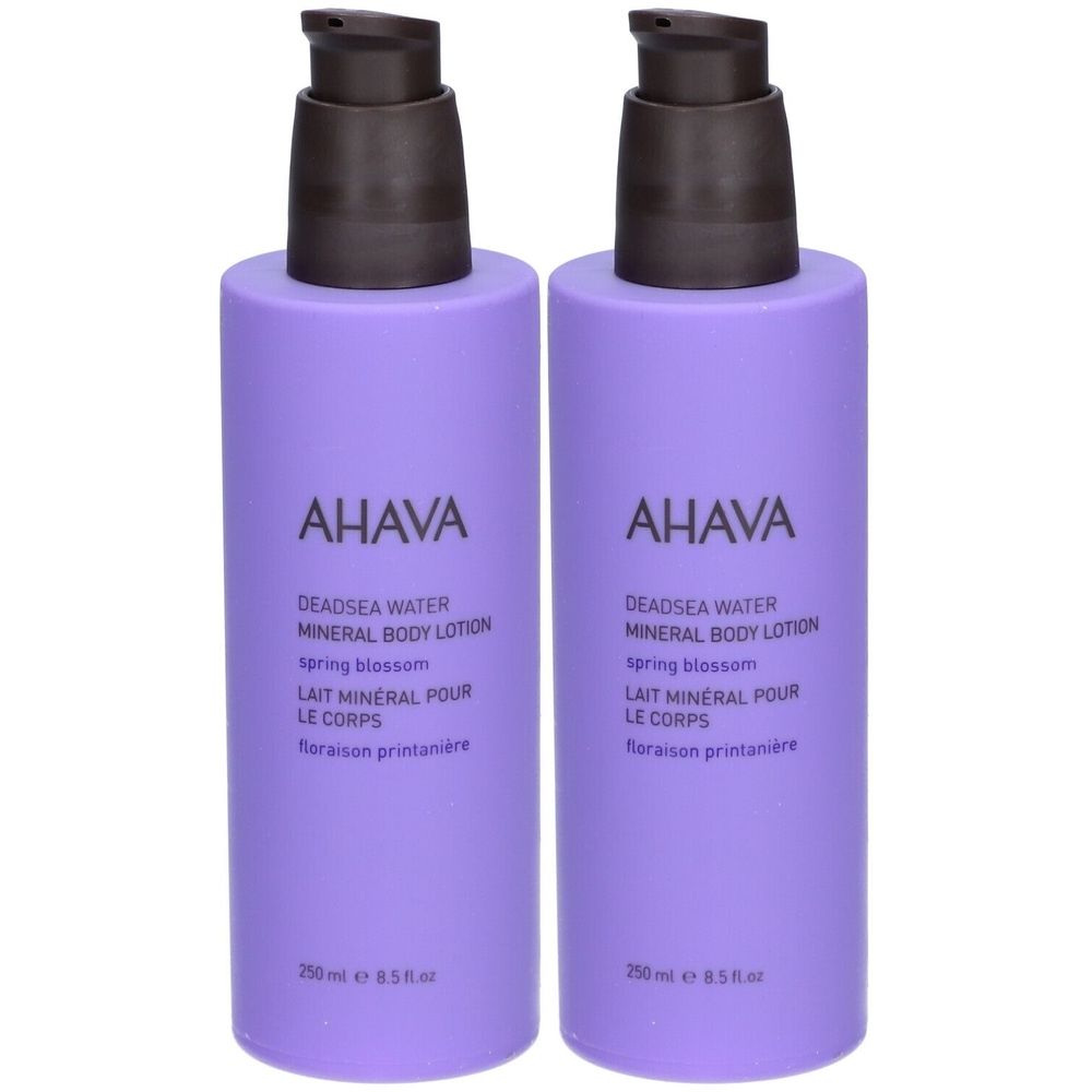 Deux flacons violets de lotion pour le corps AHAVA avec pompes noires. Texte: Deadsea Water Mineral Body Lotion.
