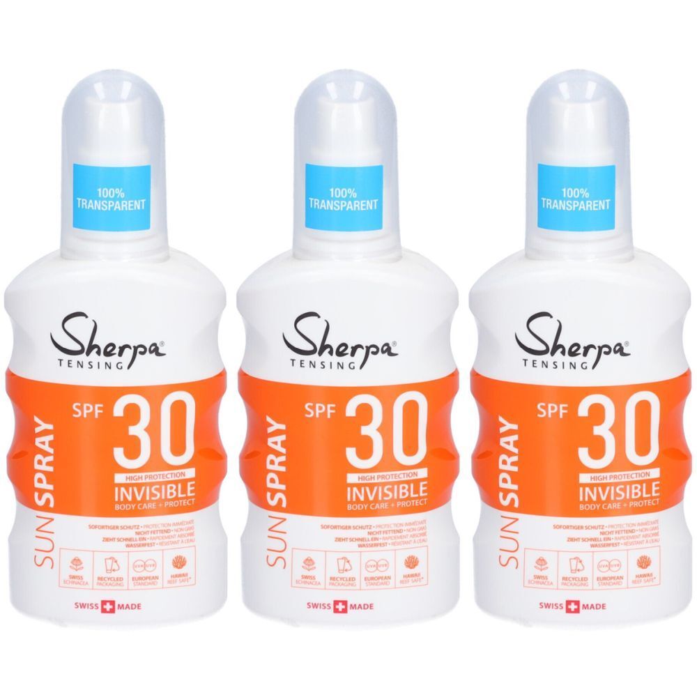 Trois flacons blancs avec étiquettes orange. Inscription : Sherpa Tensing SPF 30 Invisible Sun Spray. Bouchon bleu avec inscription : 100% Transparent.
