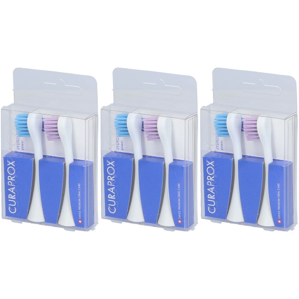 Trois têtes de brosse à dents dans des emballages individuels. Manches bleus et blancs, poils bleus et violets. Emballage avec logo CURAPROX.