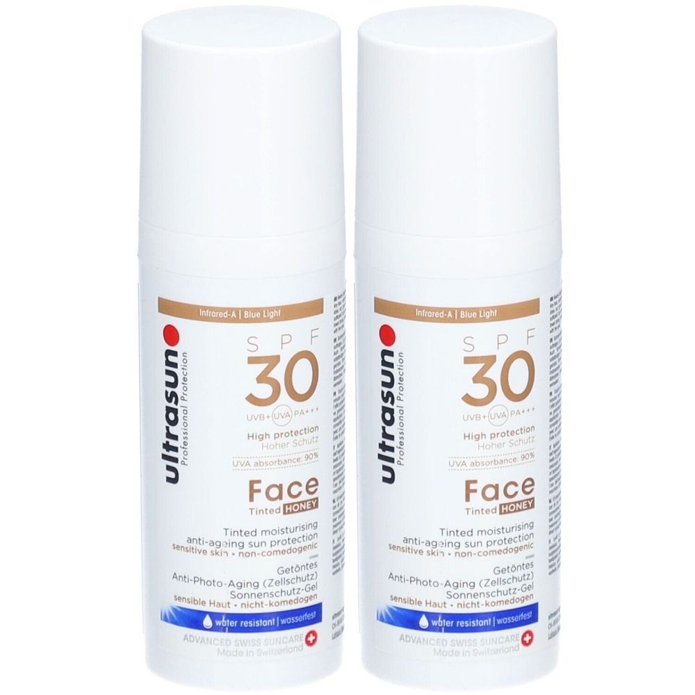 Deux flacons blancs de crème solaire. Inscription : SPF 30, Face, ultrasun. Crème solaire teintée anti-âge.