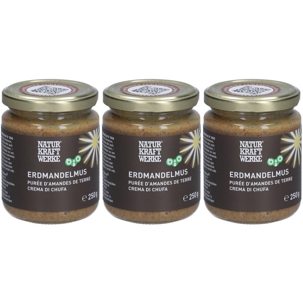 Trois pots de purée d'amandes de terre bio. Purée brune dans des bocaux en verre avec des couvercles dorés. Étiquette avec texte.