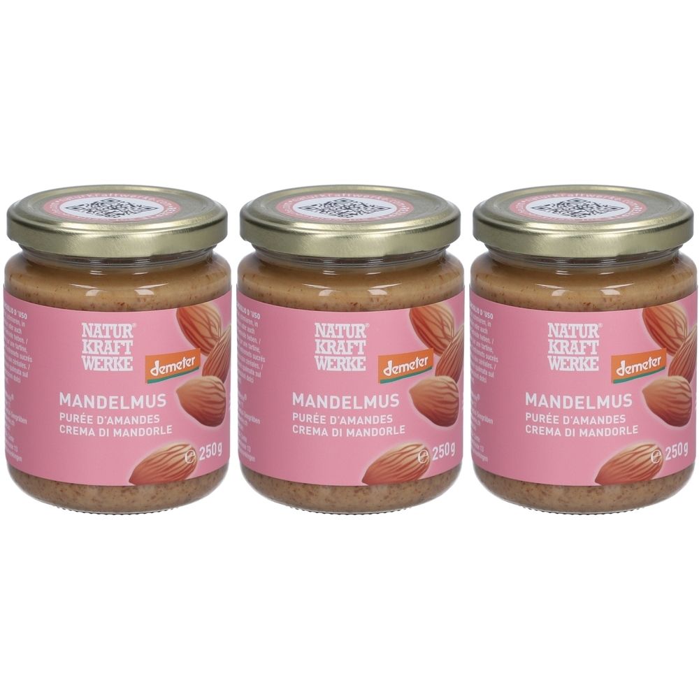 Trois pots de purée d'amandes avec étiquette rose. Inscription : NATURKRAFTWERKE, MANDELMUS, label Demeter. Couvercles dorés.