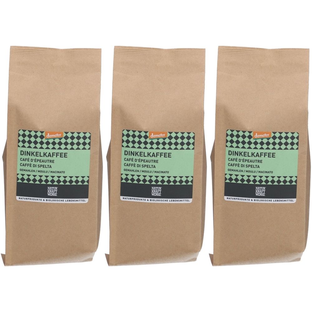 Trois paquets de café d'épeautre. Chaque paquet a une étiquette verte avec des informations sur le produit. L'emballage est en papier brun.