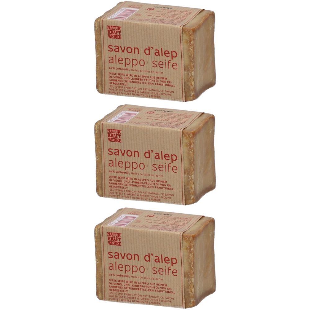 Trois blocs de savon d'Alep emballés dans du papier brun. Inscription : savon d'alep, aleppo seife. Logo Natur Kraft Werke.