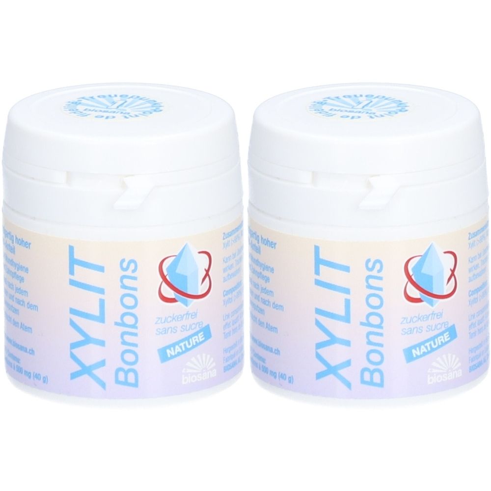 Deux pots blancs avec étiquette bleu et blanc. Inscription: XYLIT Bonbons, sans sucre. Logo: cristal bleu.