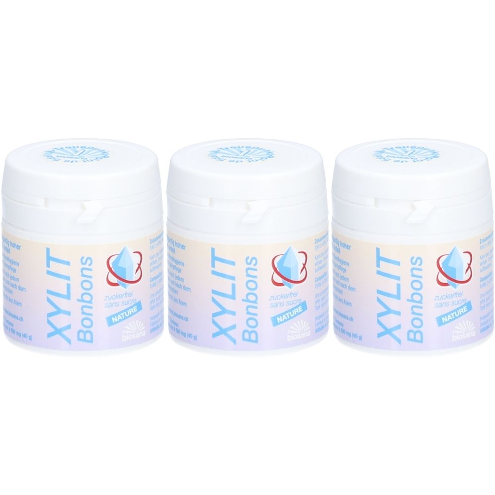 Trois pots blancs avec couvercles bleu et blanc. Chaque pot porte l'inscription "XYLIT Bonbons" et un logo goutte.