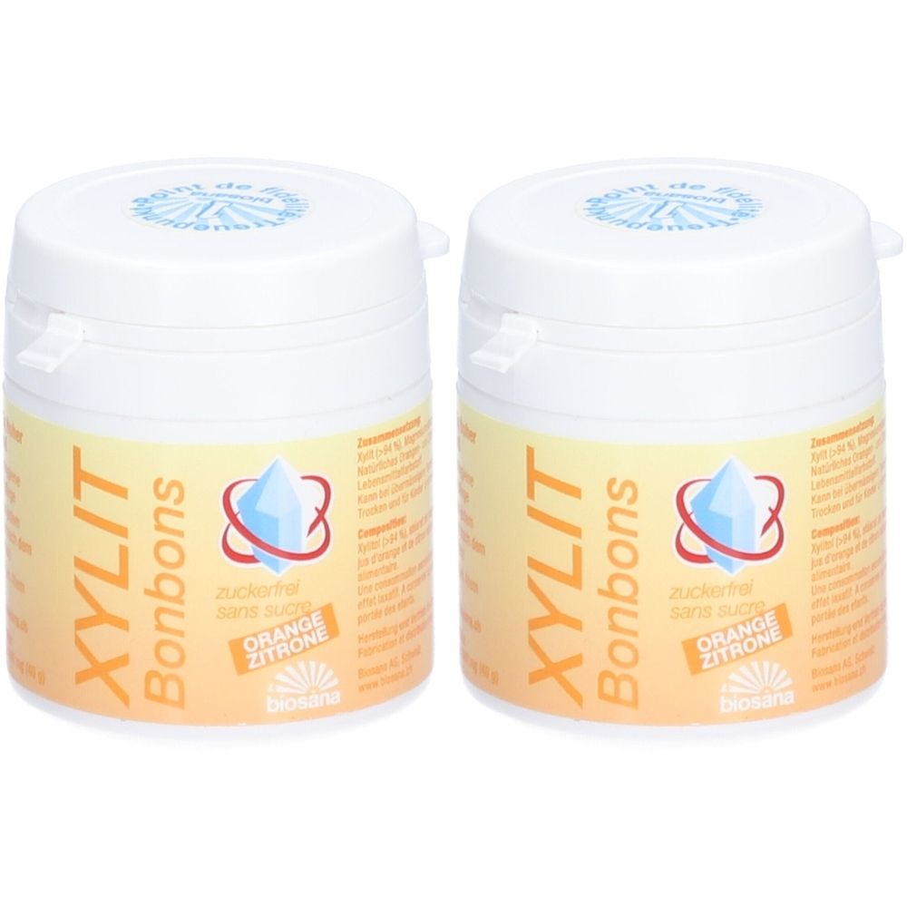Deux boîtes blanches de bonbons Xylit. Inscription: Orange Citron, sans sucre. Marque Biosana.