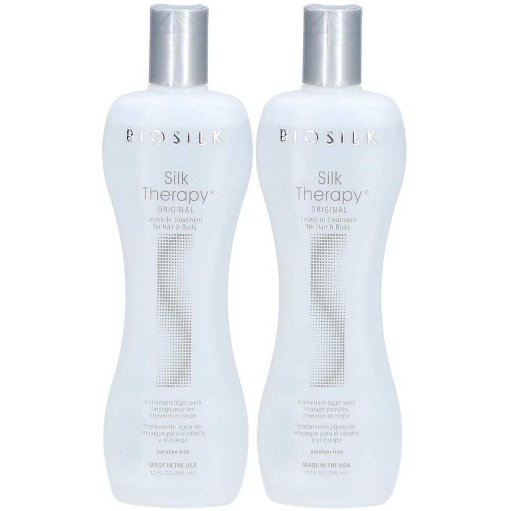 Deux flacons de BioSilk Silk Therapy Original. Flacons blancs avec bouchons argentés. Texte: Leave-in Treatment pour cheveux et corps.