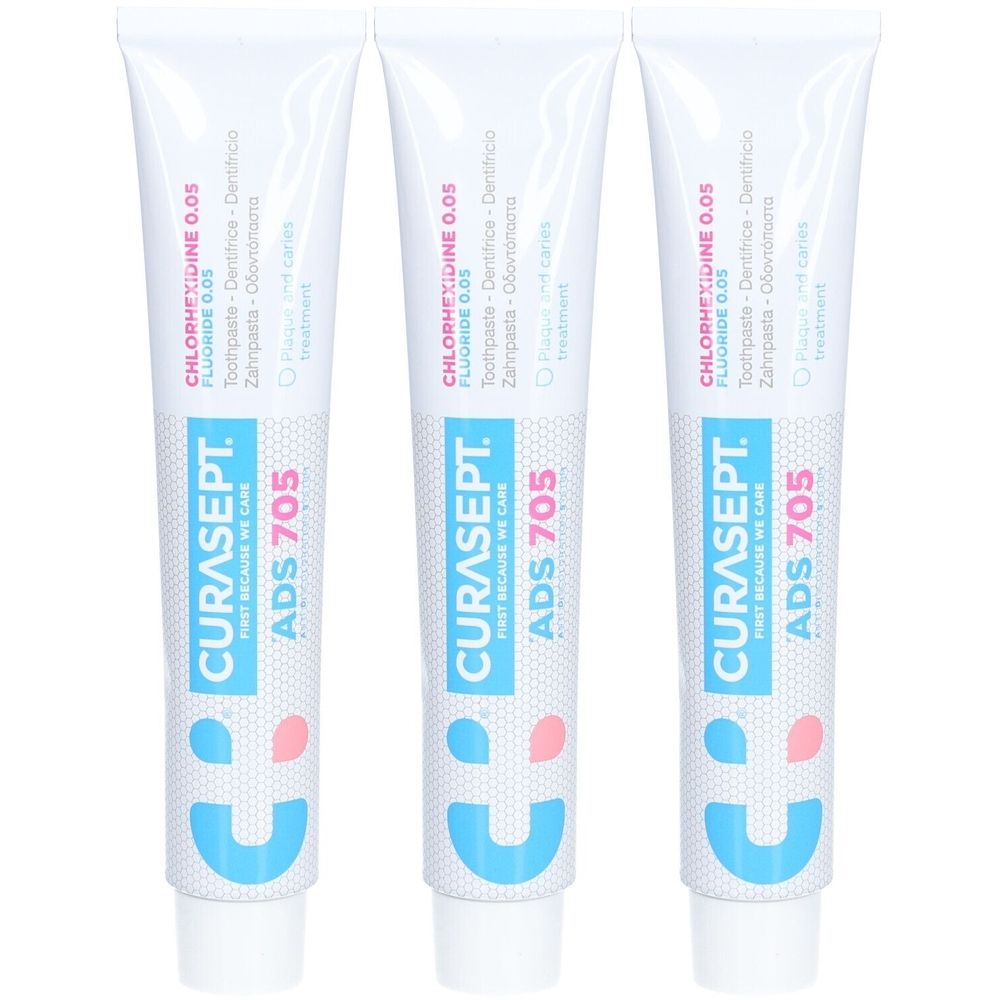 Trois tubes de dentifrice blancs avec texte bleu et rose. Inscription: CURASEPT ADS 705, Chlorhexidine 0,05, Fluorure 0,05.