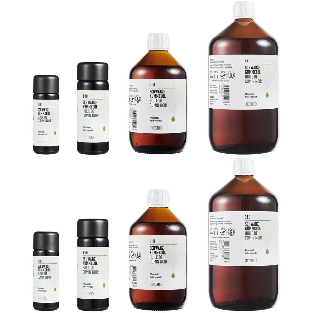 Plusieurs bouteilles et petits flacons étiquetés. Inscription : BIO Huile de cumin noir, Schwarzkümmelöl.