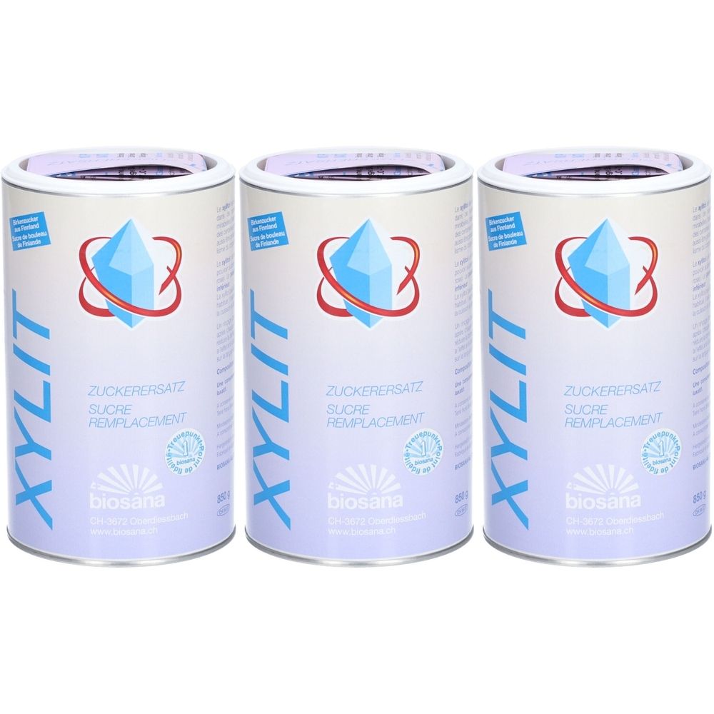 Trois boîtes cylindriques avec étiquette bleu et blanc. Inscription: XYLIT, sucre de remplacement. Logo cristal bleu et ruban rouge. Marque: biosana.