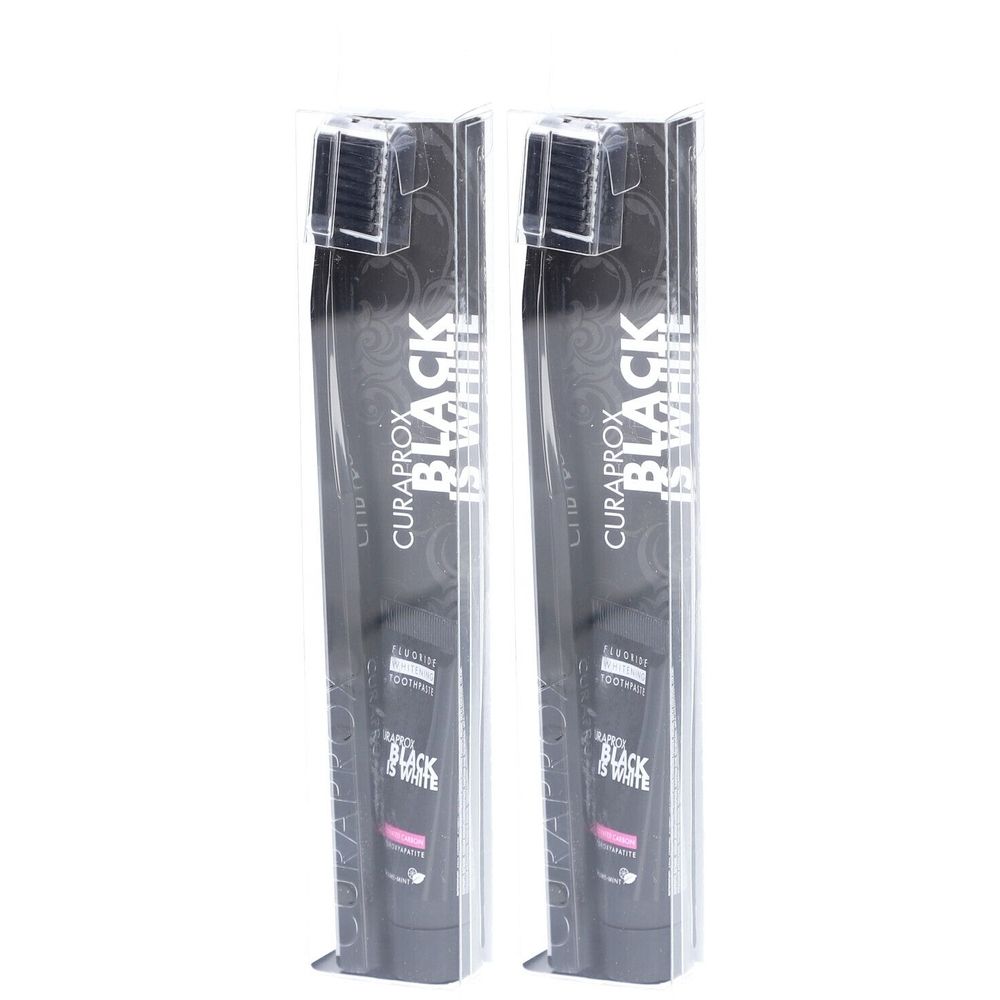 Deux brosses à dents dans un emballage transparent. L'emballage porte la mention "CURAPROX BLACK IS WHITE". Les brosses ont des poils noirs.