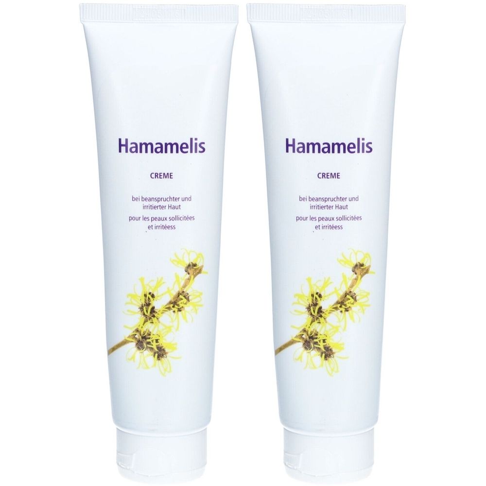 Deux tubes blancs avec l'inscription violette "Hamamelis Creme". Texte en dessous et illustration florale jaune.