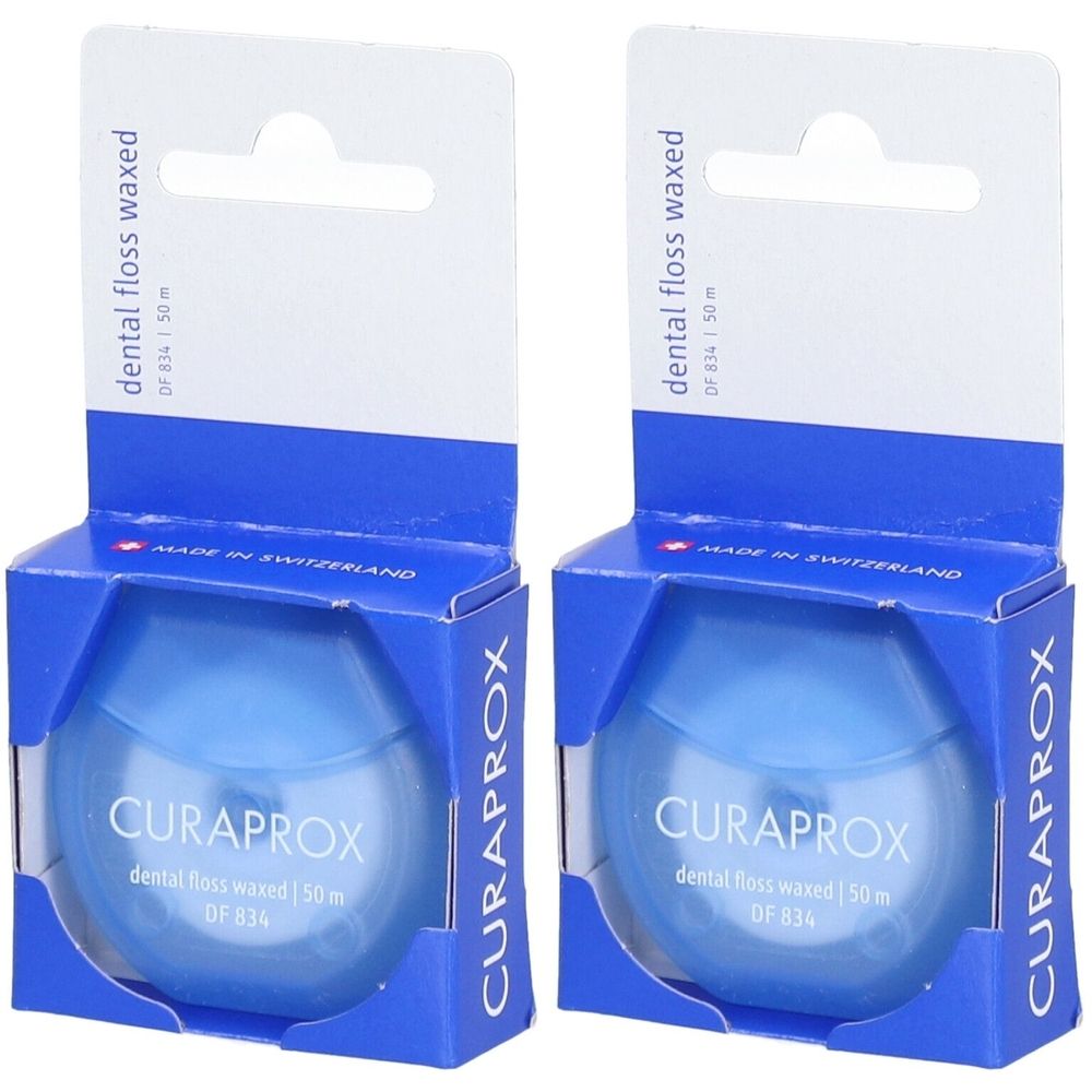 Deux boîtes de fil dentaire bleu. Inscription: CURAPROX, dental floss waxed, DF 834, 50m. Emballage avec crochet de suspension.