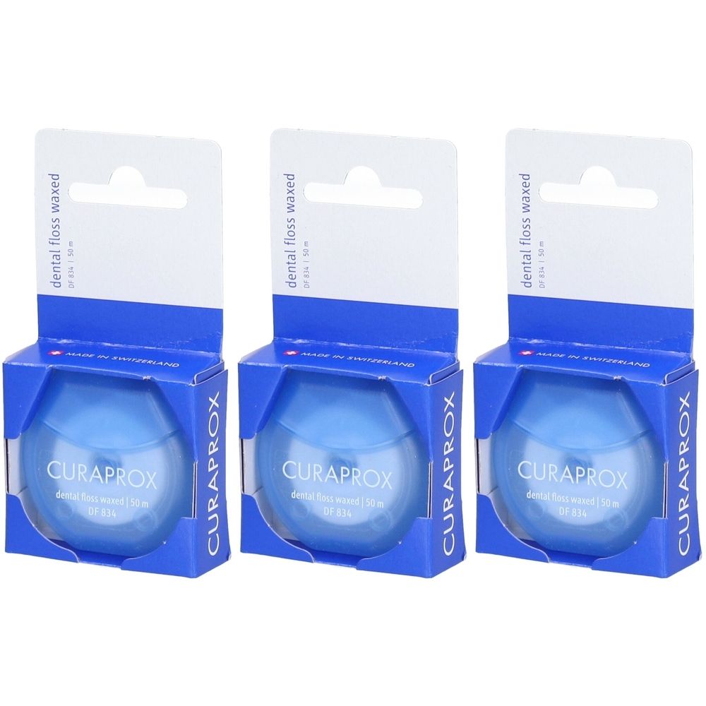 Trois boîtes de fil dentaire. Récipients bleus ronds dans des boîtes bleues avec un crochet blanc. Marque CURAPROX visible.