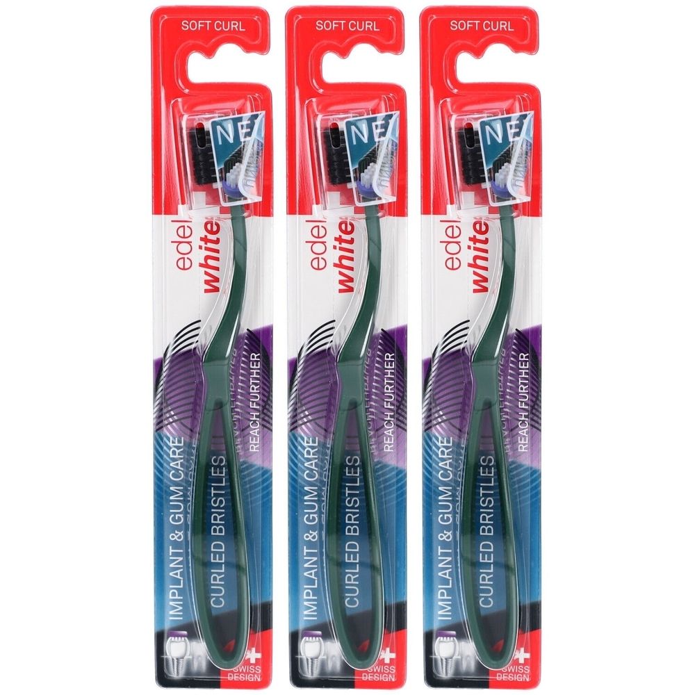 Trois brosses à dents emballées. Manches verts, soies noires. Inscription: edel white, Implant & Gum Care, Curled Bristles.