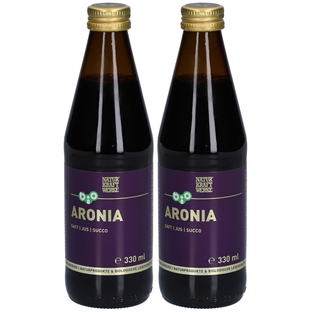Deux bouteilles de jus d'aronia. Bouteilles en verre brun avec bouchons dorés et étiquettes violettes. Inscription : Aroniasaft, 330 ml.