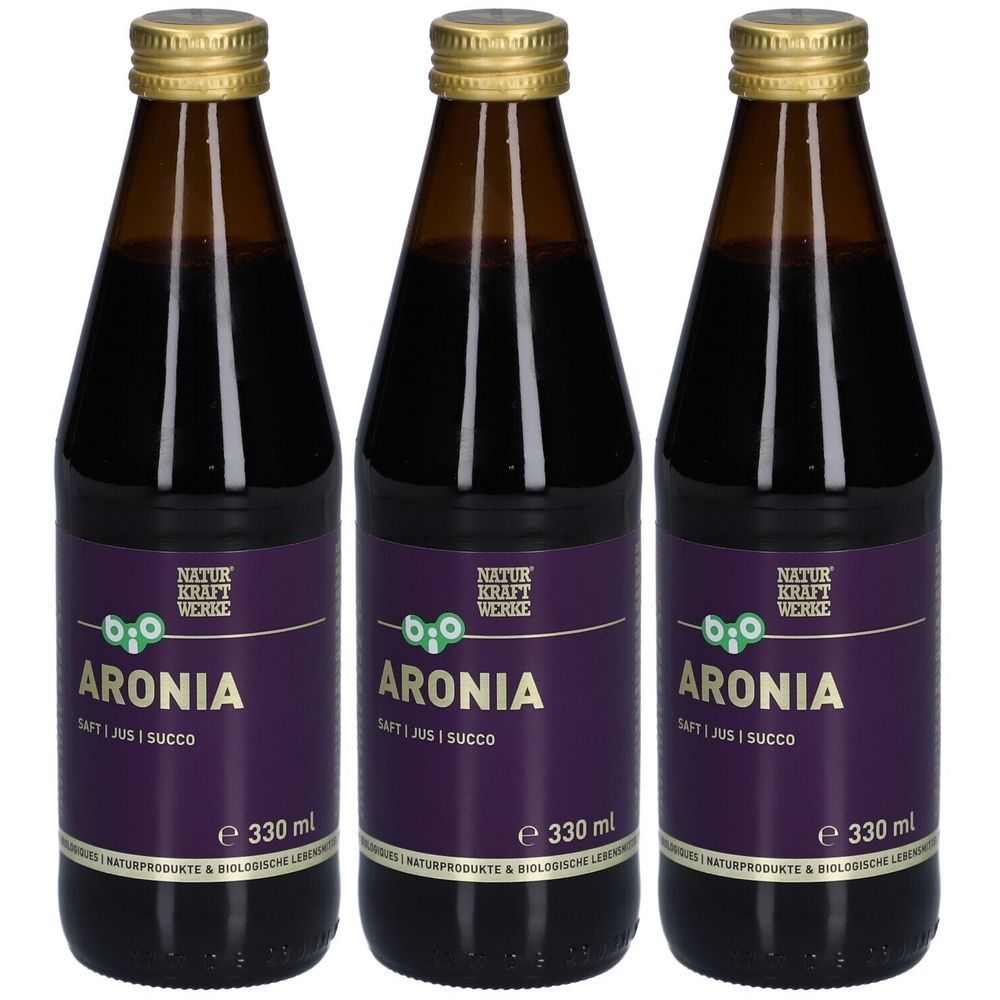 Trois bouteilles de jus foncé. Les étiquettes indiquent "ARONIA" et "330 ml". Bouchons dorés.