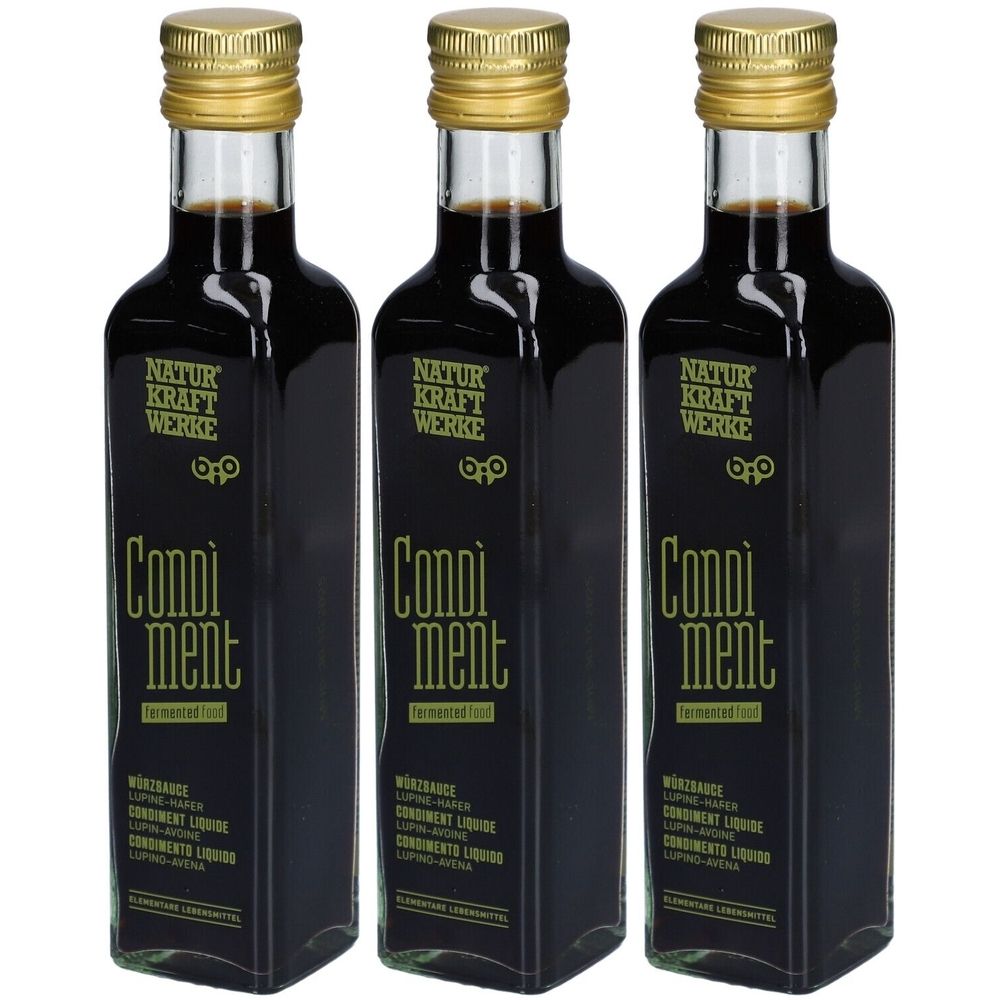 Trois bouteilles avec bouchons dorés. Inscription: NATUR KRAFT WERKE, Condiment. Liquide noir. Étiquette avec informations.