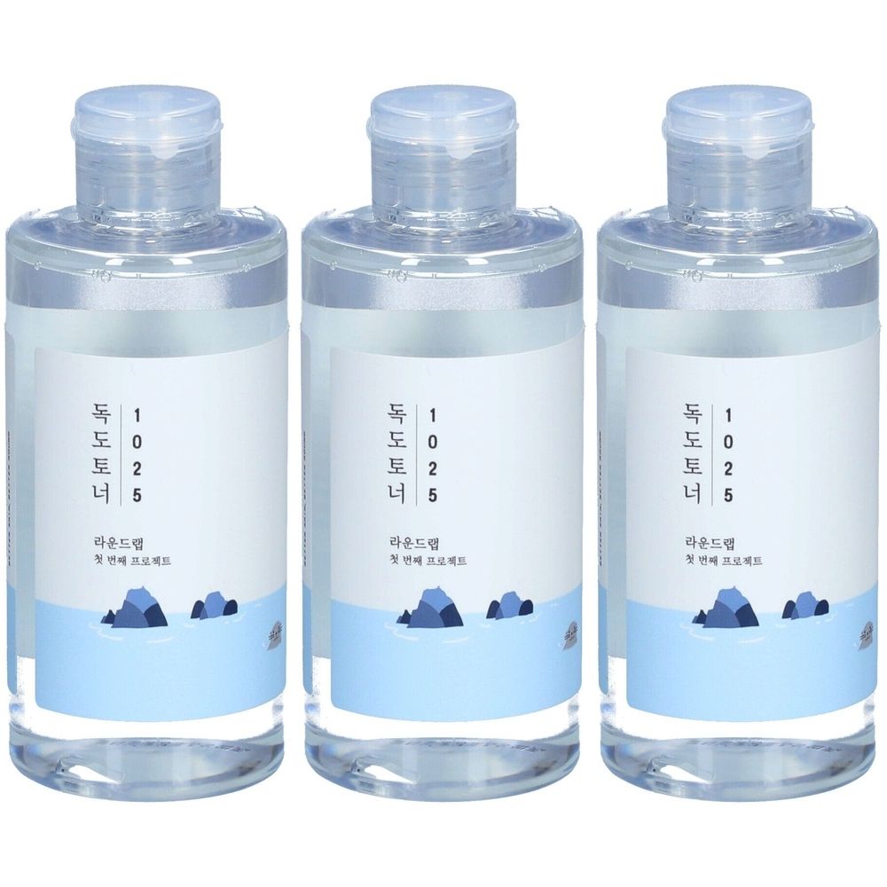 Trois flacons transparents avec étiquettes blanches et texte coréen. Paysage bleu sur l'étiquette.