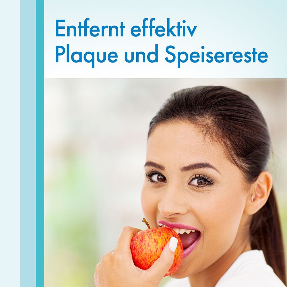 Une femme mange une pomme. Texte: Élimine efficacement la plaque et les restes alimentaires.