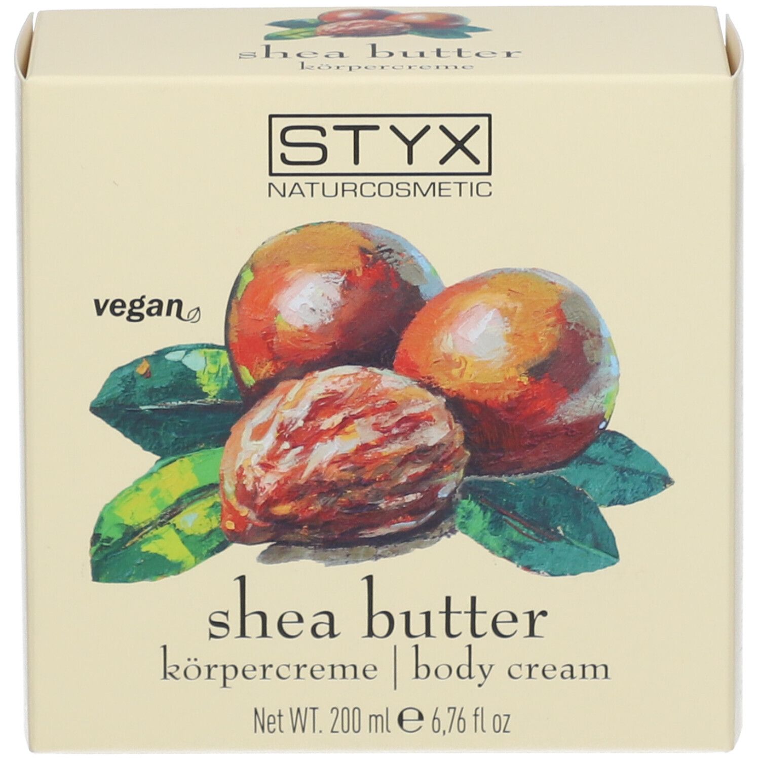 Carton avec illustration de noix de karité et de feuilles. Texte : STYX, crème corporelle au beurre de karité, vegan.